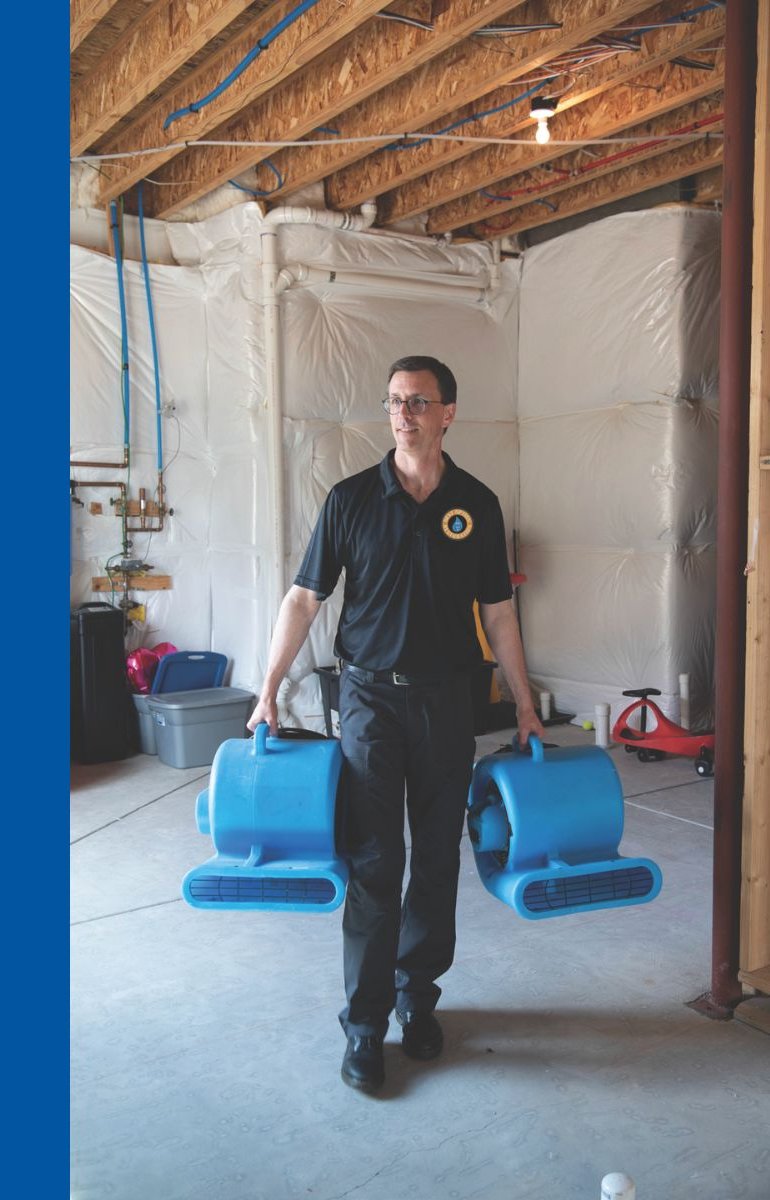 Best Option Restoration technician carrying drying equipment in a contained work area